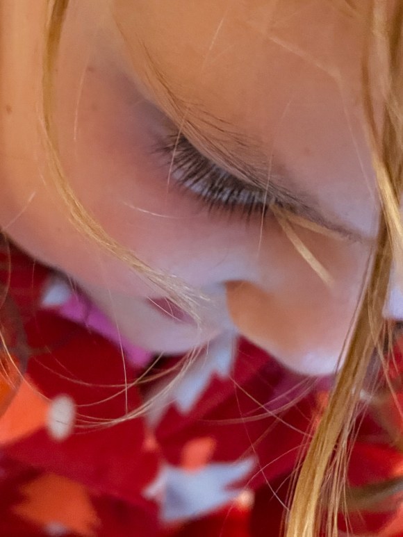 close photo of beatrix's face, smiling and looking down
